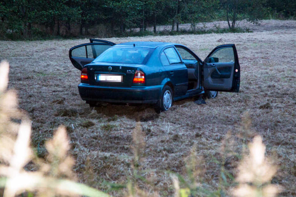 In einem Auto, das frei auf einem Feld stand, fand die Polizei eine tote Frau. Neben dem Wagen lag ein schwer verletzter Mann. (Symbolbild)