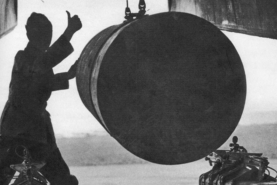 Ein Waffenmeister bringt eine 4.000 Pfund schwere Luftmine, auch Wohnblockknacker genannt, unter dem Bombenschach einer Lancaster in Position.