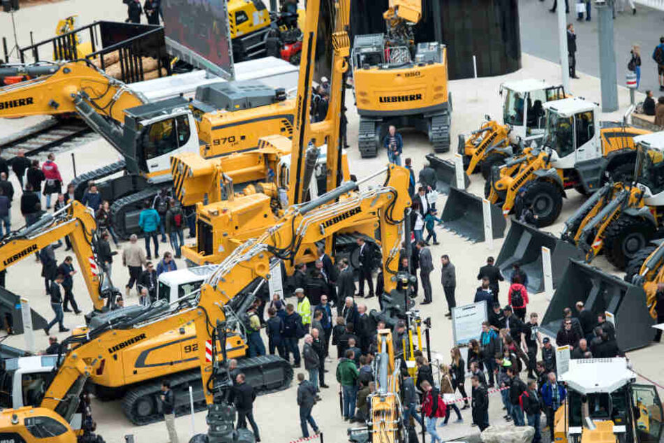 Besucher gehen während der Baumesse Bauma über den Messestand der Firma "Liebherr".