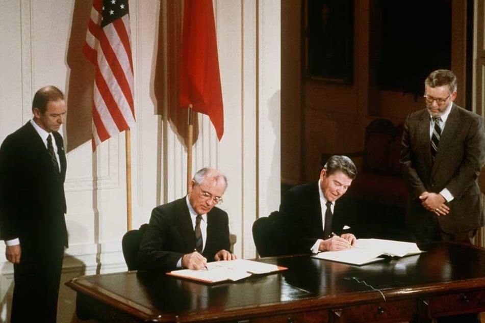 Der damalige US-Präsident Ronald Reagan (r) und der damalige sowjetische Parteichef Michail Gorbatschow unterzeichnen am 8.12.1987 den INF-Vertrag zur Vernichtung der atomaren Mittelstreckenraketen.