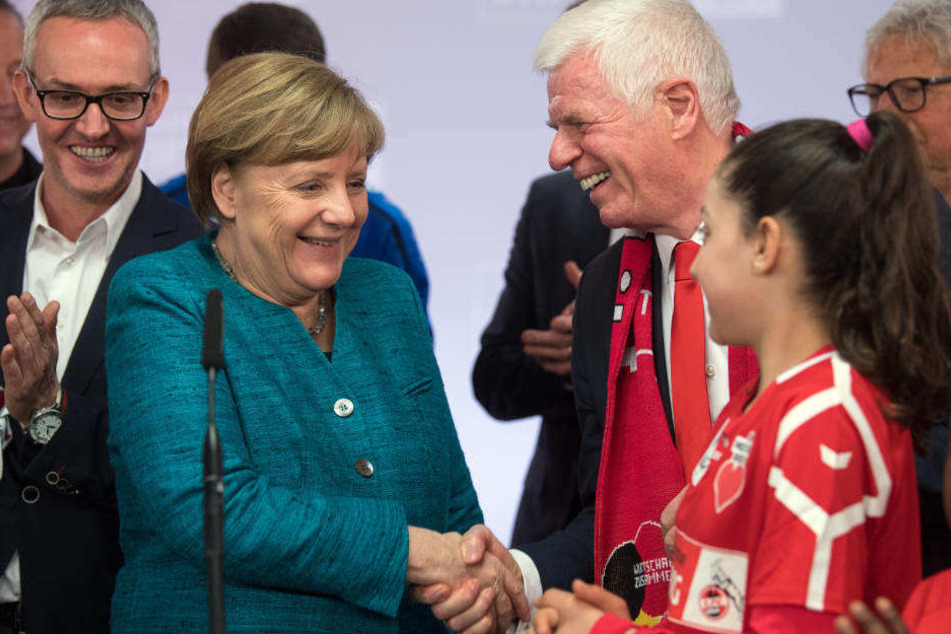 Bundeskanzlerin Merkel trifft im April 2017 bei der Veranstaltung "Wir zusammen" der Stiftung des 1. FC Köln Flüchtlingskinder und FC-Präsident Werner Spinner (r.).