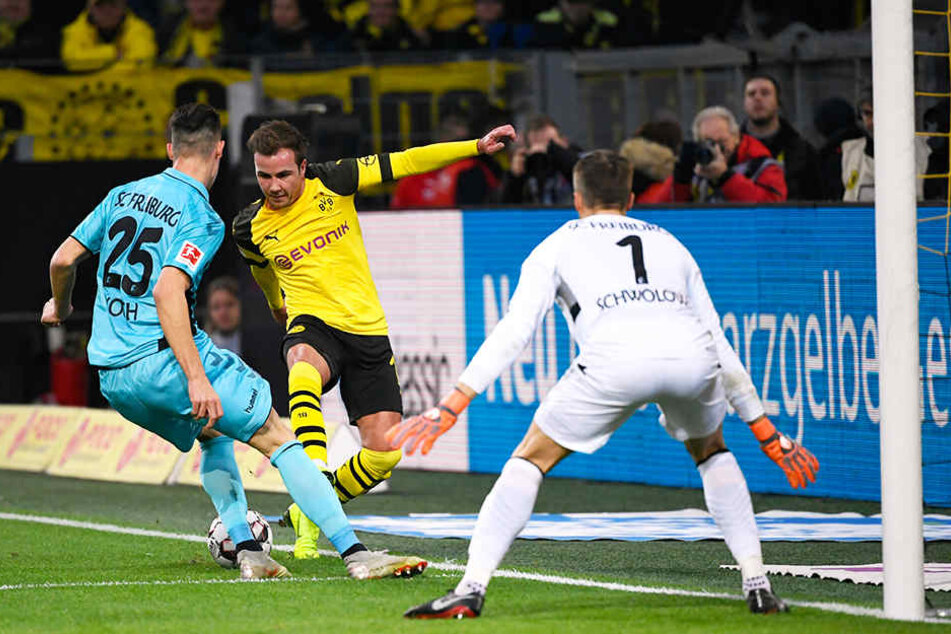 BVB-Stürmer Mario Götze versucht an Freiburgs Abwehrmann Robin Koch (l.) und SCF-Keeper Alexander Schwolow (r.) vorbeizukommen.