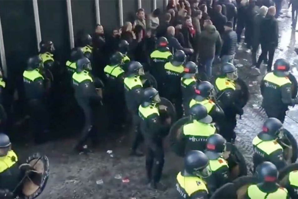 Niederländische Polizei drängt Fußballfans zurück.