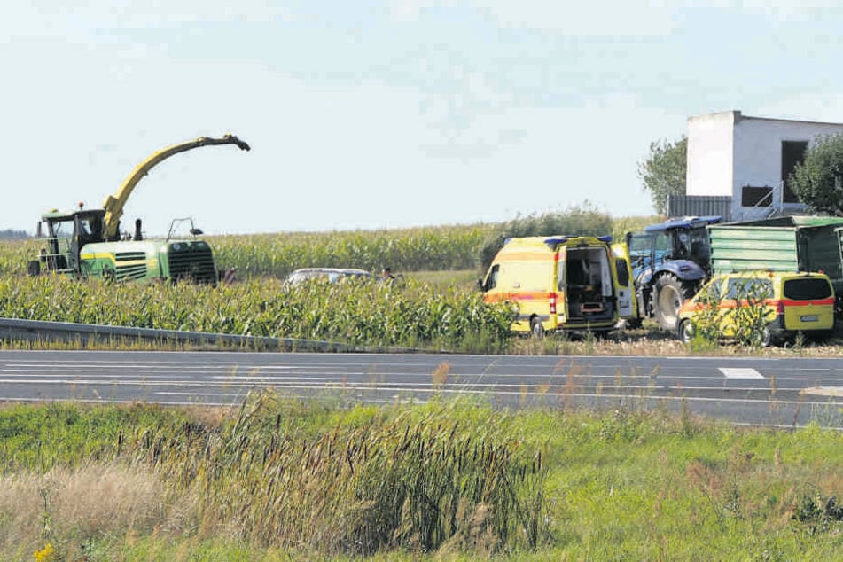 Notarzt und Rettungssanitäter kümmern sich auf dem Maisfeld um den schwer verletzten Rentner. Links im Bild ist der 500 PS starke Häcksler zu sehen.