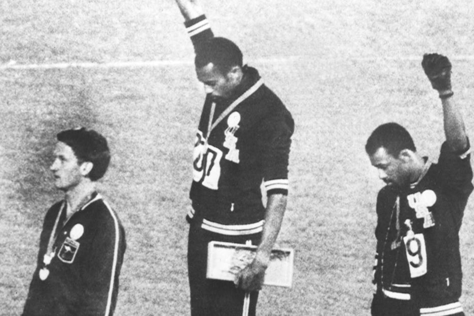 Tommie Smith (M.) und John Carlos heben bei der Siegerehrung der Olympischen Spiele 1968 die Faust als Symbol der Black-Power-Bewegung.