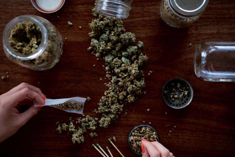Eine Frau baut sich aus Marihuana-Bröseln einen Joint zusammen.