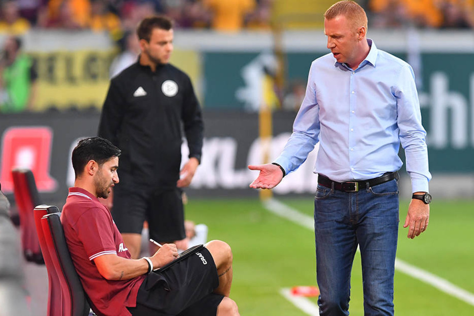 Dynamo-Coach Maik Walpurgis (r.) nimmt während eines Spiels kurz Rücksprache mit seinem am Tablet arbeitenden Co-Trainer Ovid Hajou und holt sich dabei wichtige, möglicherweise sogar spielentscheidende Informationen.