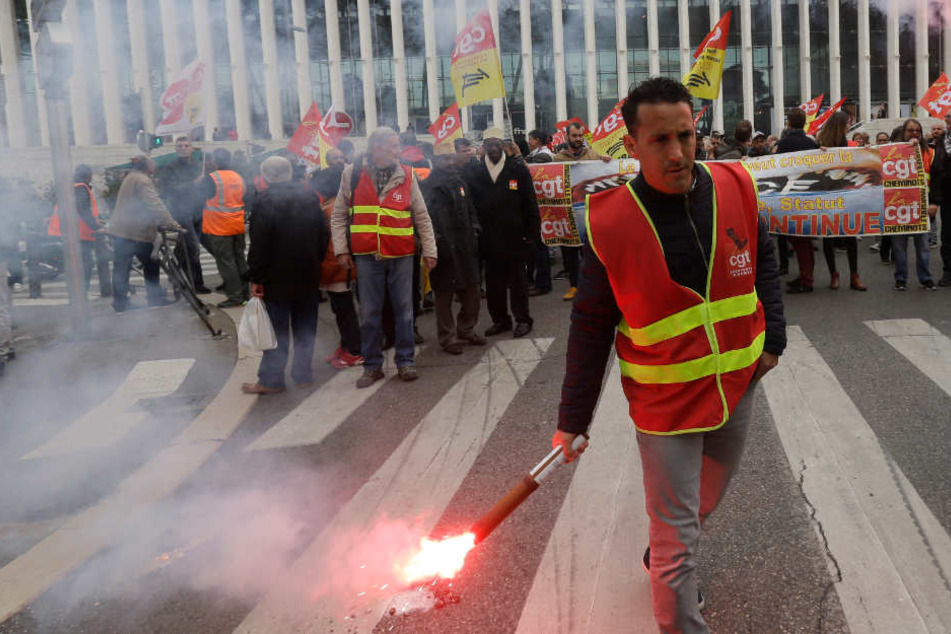 Ein Demonstrant hält bei einem Protest vor dem Bahnhof Saint Charles in Südfrankreich eine Fackel in der Hand. (Archivbild)