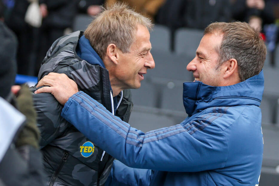 Jürgen Klinsmann (l) und Hansi Flick begrüßen sich vor dem Anpfiff im Berliner Olympiastadion.