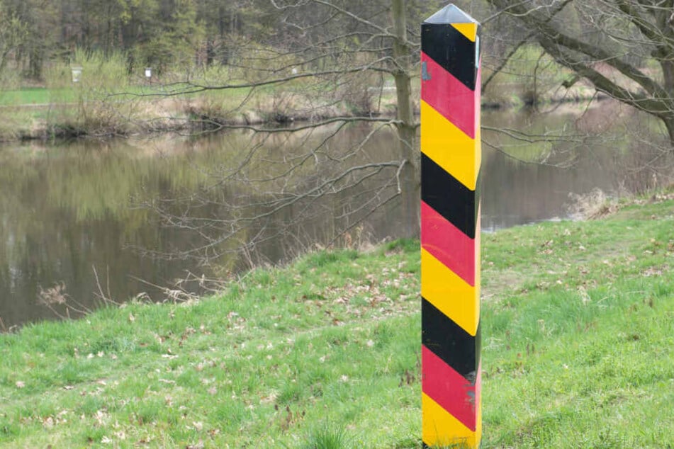 Ein Grenzpfahl markiert am Ufer der Neiße in Görlitz die deutsch-polnische Grenze.