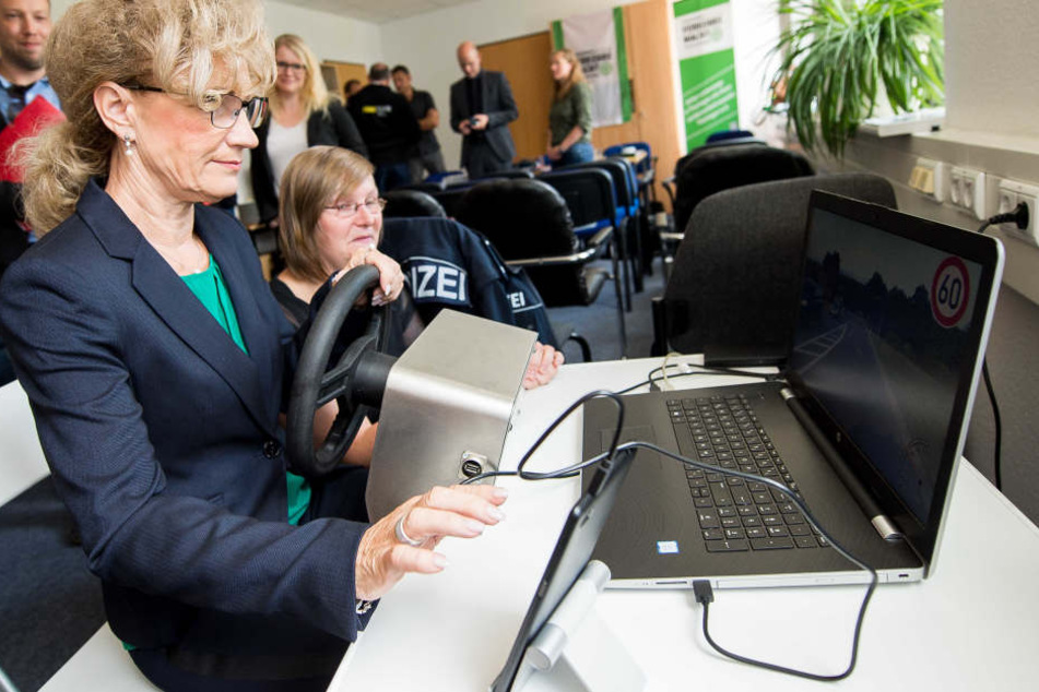 Birgit Keller, Thüringer Ministerin für Infrastruktur und Landwirtschaft versucht sich an einem Fahrsimulator, welcher die verschiedenen Ablenkungen beim Autofahren darstellt. Mandy Passit von der Landesverkehrswacht erklärt ihr das Gerät.