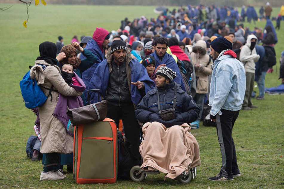 Flüchtlinge warten nahe Wegscheid an der deutsch-österreichischen Grenze.