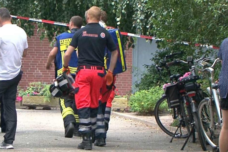 Rettungskräfte betreten das Grundstück in Neuenkirchen, auf dem die Leiche gefunden wurde.