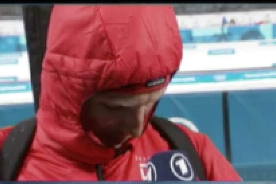 Erik Lesser schaut auf das Logo auf seiner Brust.