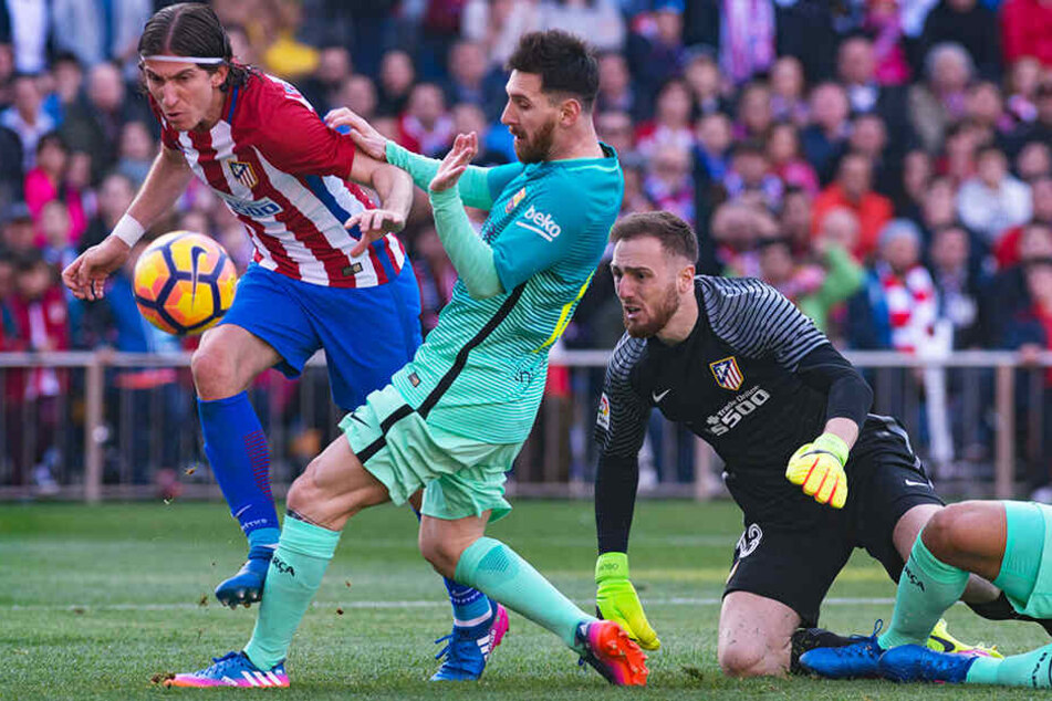 Filipe Luís (l.) knöpft hier Barcelonas Superstar Lionel Messi (M.) den Ball ab.