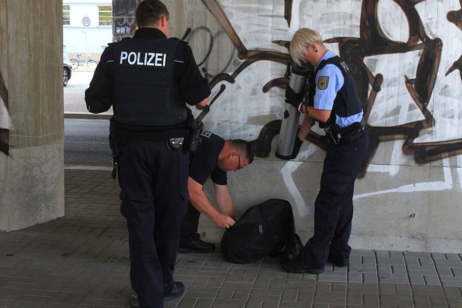 Vorsichtig inspizieren die Beamten den Koffer.
