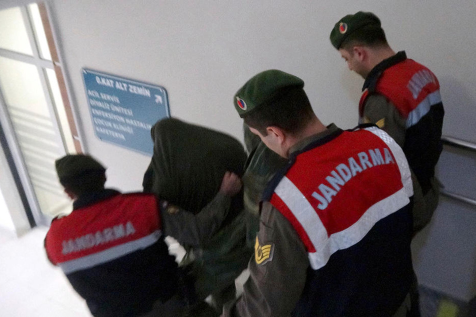 Türkische paramilitärische Polizisten führen die zwei griechischen Soldaten aus einem Gebäude heraus.