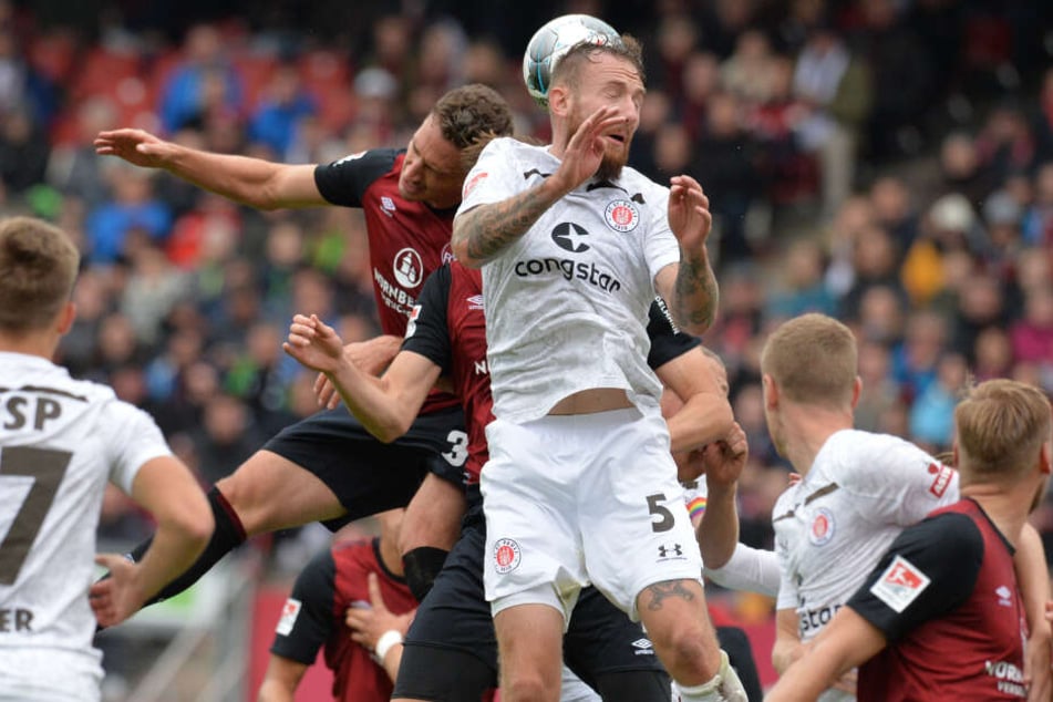 Marvin Knoll rettet bei einer Ecke per Kopf vor seinem Gegenspieler.