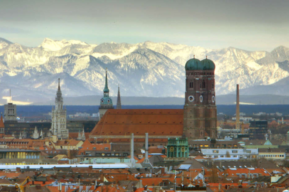 Die Münchner Frauenkirche ist vor den schneebedeckten Alpen zu sehen.