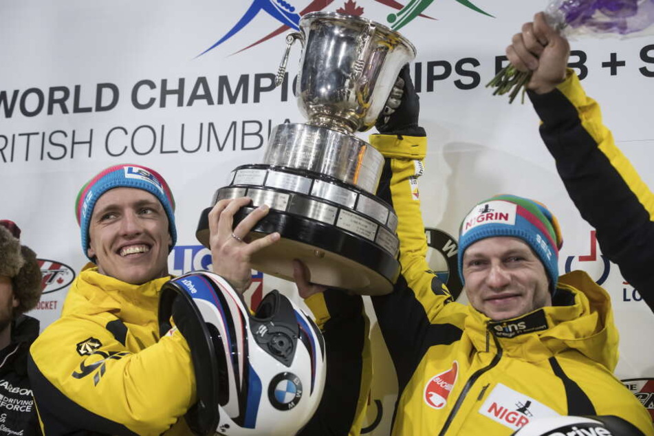 Francesco Friedrich (r) und Thorsten Margis halten den Pokal.