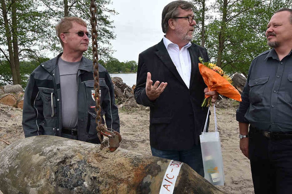 Oranienburgs Bürgermeister Hans-Joachim Laesicke (mi.) überreicht am 12.05.2015 in Oranienburg Blumen an die Sprengmeister Andre Müller (r.) und Heino Borchert. Die Bombe wurde am Ufer des Lehnitzsees gefunden.