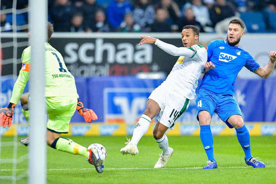 Gladbachs erste Großchance: Doch Gladbachs Alassane Plea (M.) scheitert mit seinem Schuss aus spitzem Winkel an TSG-Torhüter Oliver Baumann (l.).