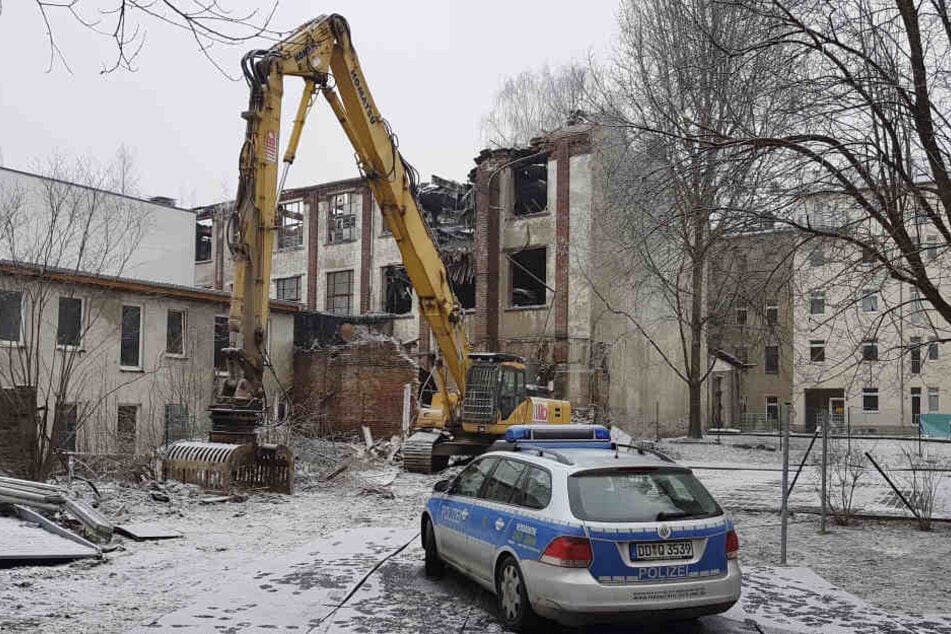 Die alte Fabrikhalle muss abgerissen werden. Der Bagger steht schon bereit.