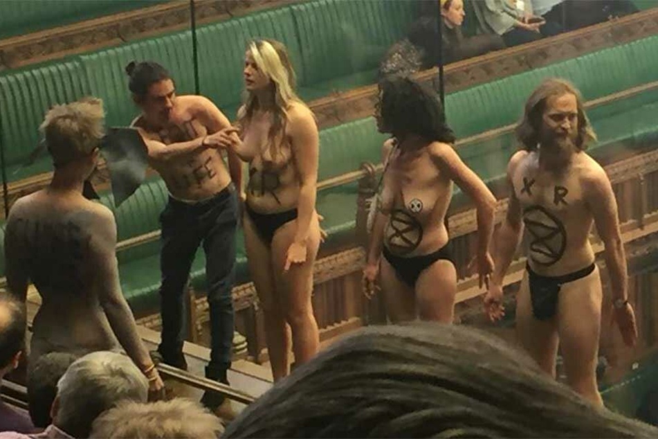 Die Aktivisten stehen nackt auf der Besuchertribüne in Westminster.