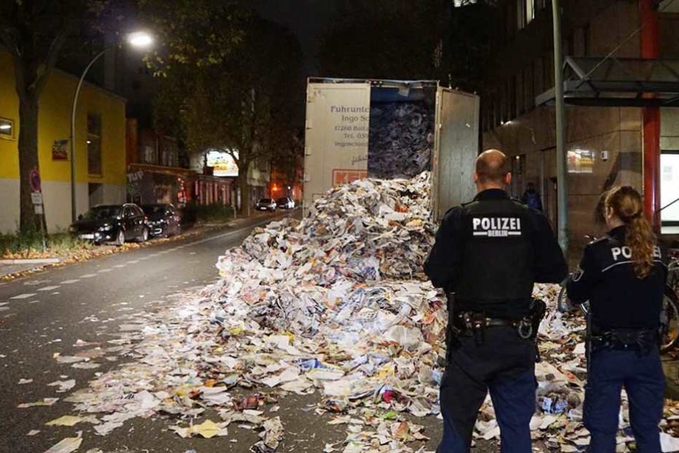 Polizisten stehen vor dem Papierberg.
