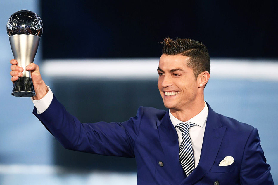 Stolz reckt Cristiano Ronaldo den Pokal als bester Fußballer der Welt nach oben.
