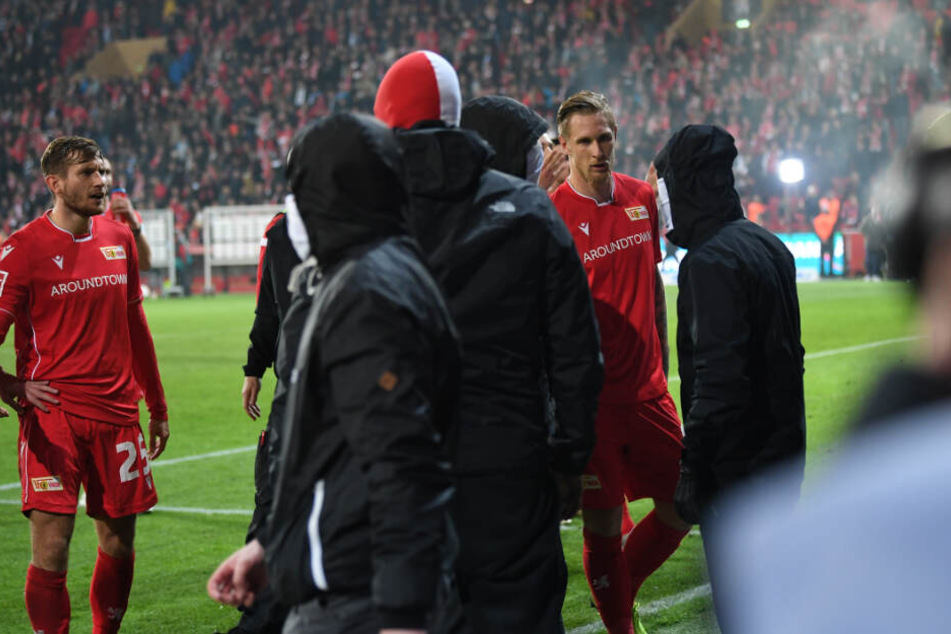 Unions Sebastian Polter (r) versucht nach dem Abpfiff und dem Sieg seines Teams im Derby vermummte Fans zu beschwichtigen.
