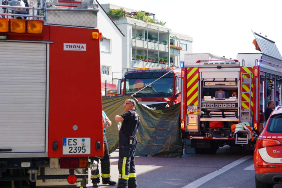 Einsatzkräfte an der Unfallstelle. Ein Sichtschutz ist aufgestellt worden.