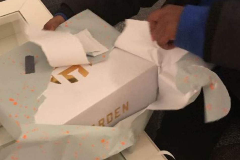 Tarik packt sein Geschenk aus.