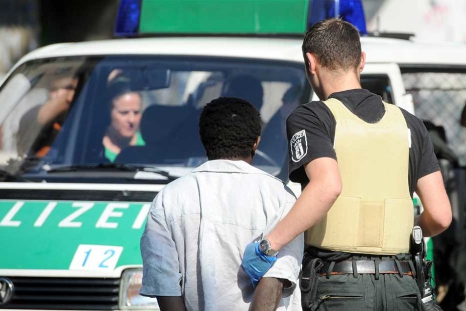 Ein Polizei hat während einer Razzia einen mutmaßlichen Drogendealer in Gewahrsam genommen..