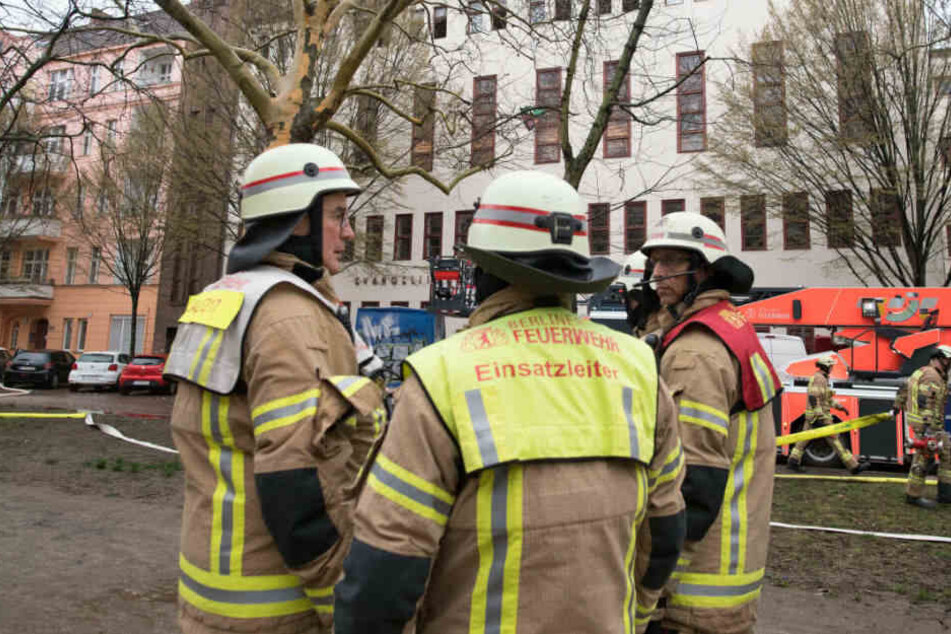 Einsatzkräfte stehen vor dem Haus, wo es zu einem Wohnungsbrand kam.