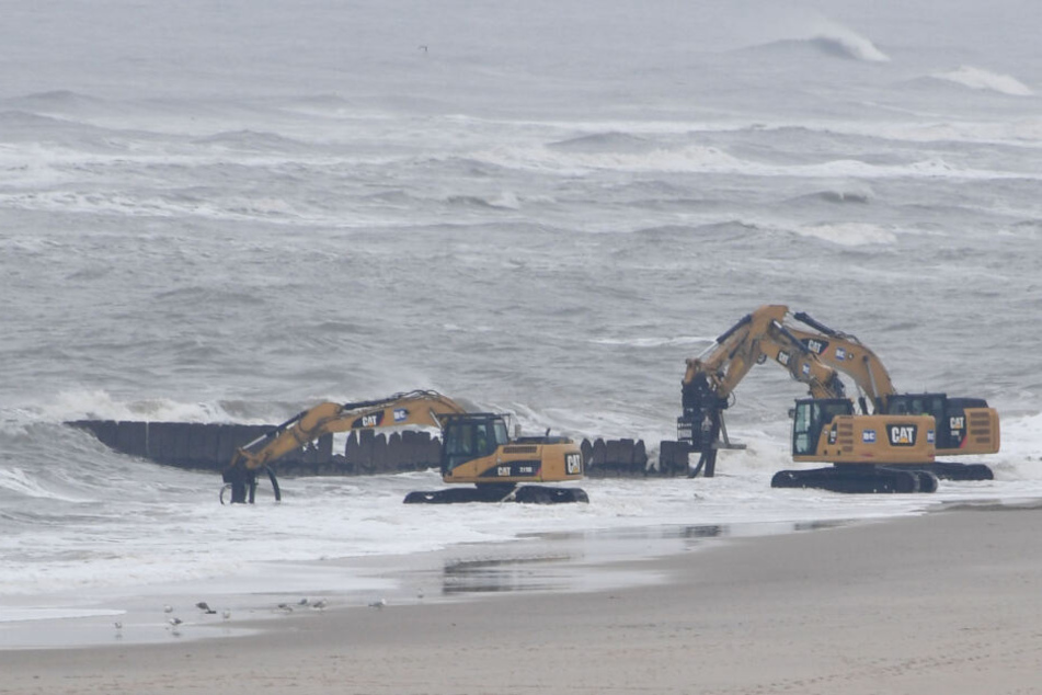 Bagger arbeiten nach dem Sturmtief "Sabine" am Strand der Nordseeinsel Sylt.