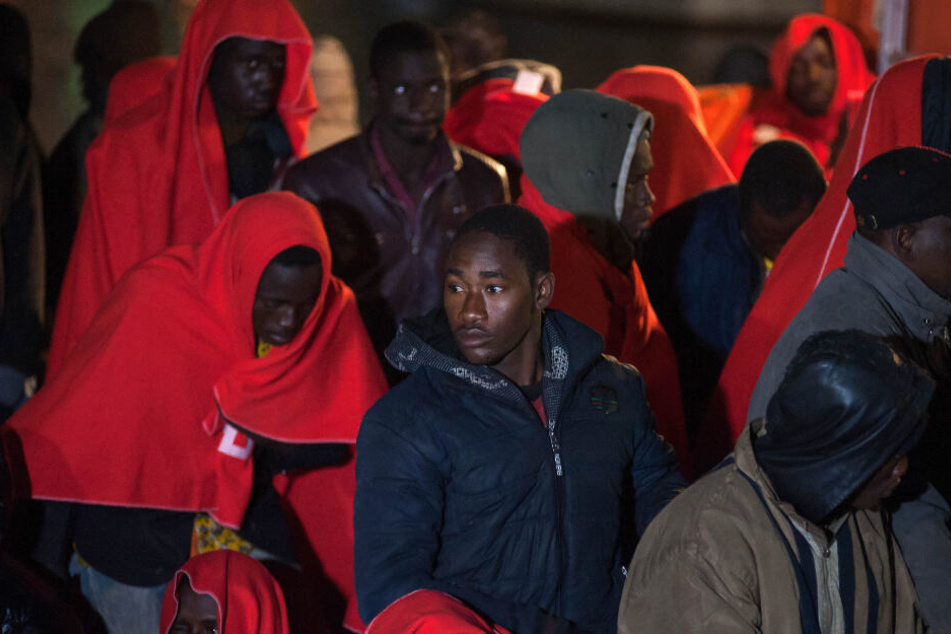 Migranten stehen auf einem Rettungsboot, während sie nach ihrer Ankunft im Hafen von Málaga darauf warten, von Bord zu gehen.