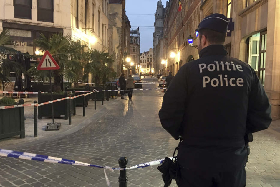 Ein Polizist steht hinter einem Polizeiband während der Ermittlungen am Ort einer Messerattacke im Zentrum von Brüssel.