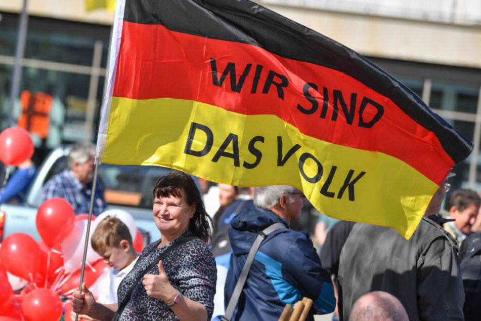 Eine Demonstrantin hält eine Deutschlandfahne mit der Aufschrift "Wir sind das Volk".