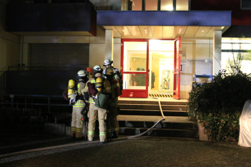 Feuerwehr-Männer am Eingang des Hochhauses in der Ringslebenstraße.