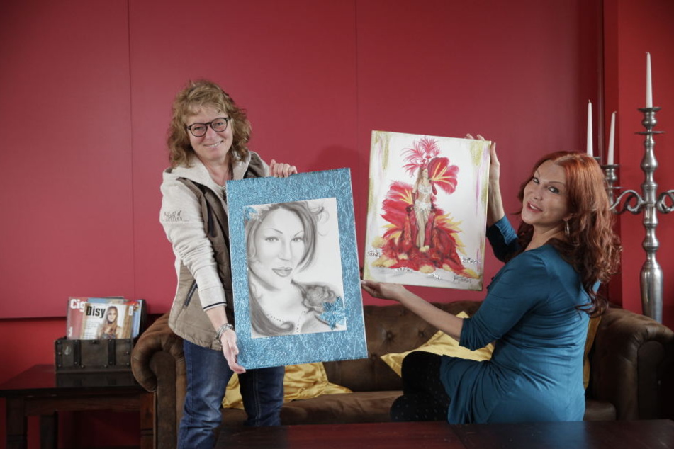 Katarina Mergen (46, l.) überreicht Zora Schwarz ihre beiden Bilder.
