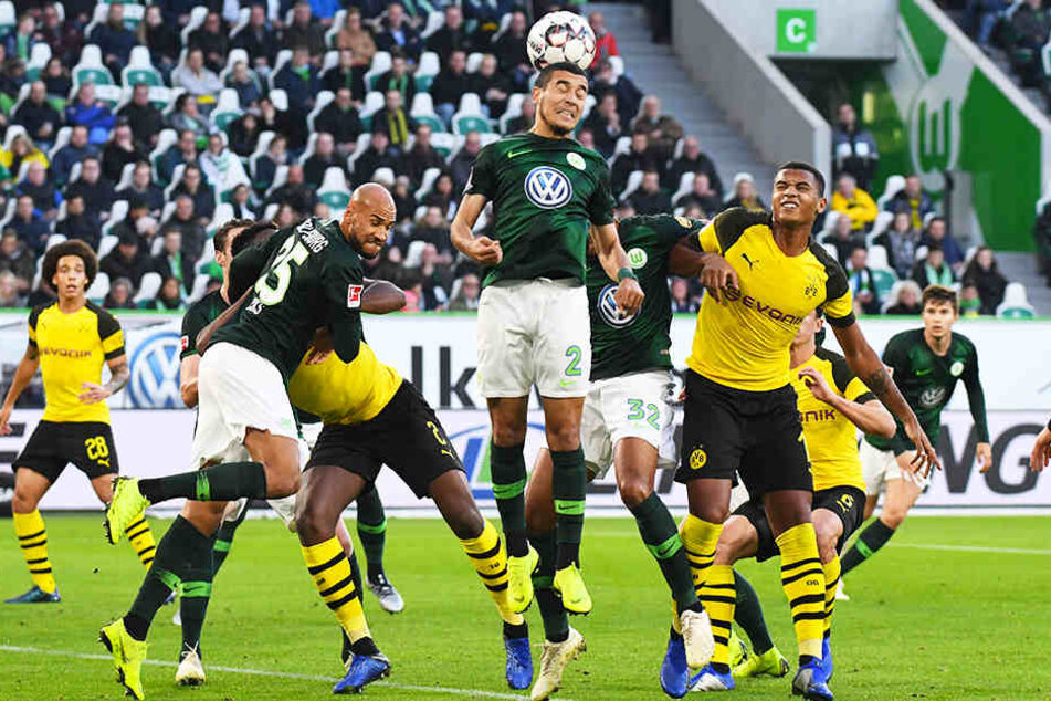 Wolfsburgs William (M., köpft den Ball weg) kann den Eckball vor den lauernden BVB-Angreifern klären.