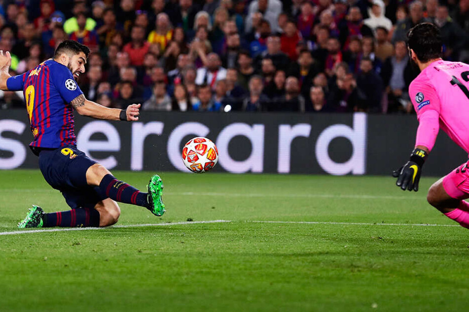 Barca-Stürmer Luis Suarez (l.) grätscht den Ball an Liverpool-Keeper Alisson vorbei zum 1:0 für die Hausherren ins Netz.