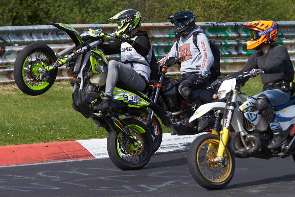 Ein Motorradfahrer fährt beim Korso zum Saisonauftakt unter dem Motto "Anlassen" auf dem Nürburgring auf dem Hinterrad.