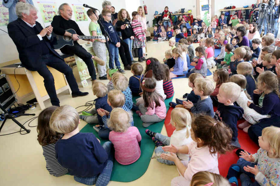 Kinderliedermacher Rolf Zuckowski und das Autorenteam Dieter Faber und Wolfram Eicke (oben v.l) stellen den Kindern einer Kita ein neues Hörspiel vor.