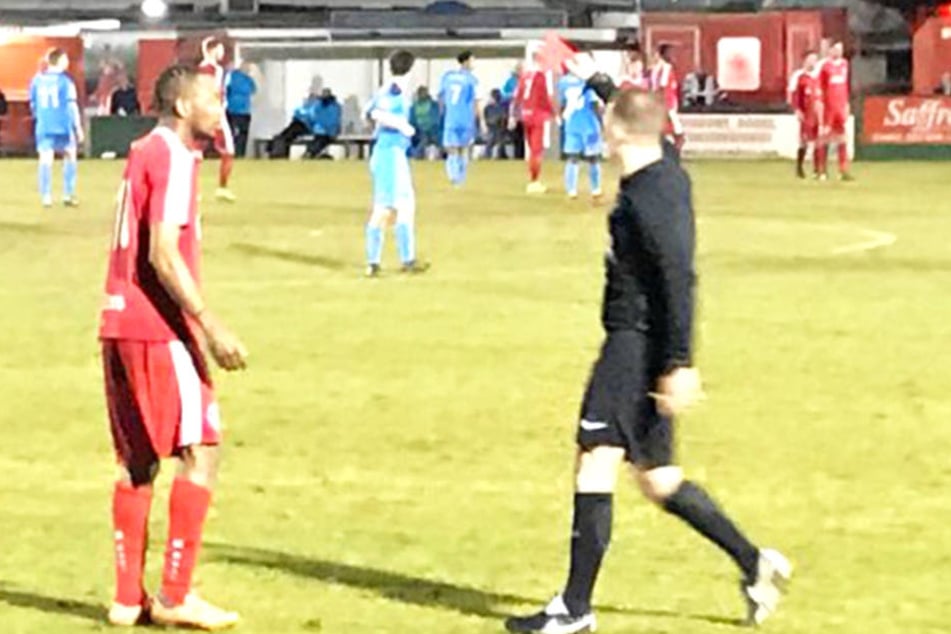 Der Schiedsrichter schickt einen fassungslosen Spieler vom Platz.