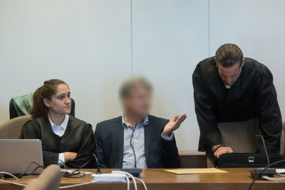 Ein Angeklagter (M) sitzt vor der Urteilsverkündung im Prozess um den Einsturz des Kölner Stadtarchivs in einem Gerichtssaal des Landgerichts.