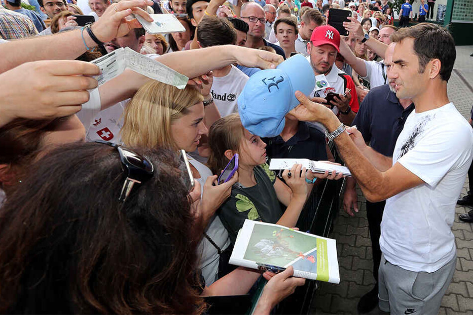 Der Maestro bei der "Arbeit" nach dem Tennis: Roger Federer erfüllt geduldig Autogrammwünsche der Fans bei den Gerry Weber Open in Halle Westfalen.