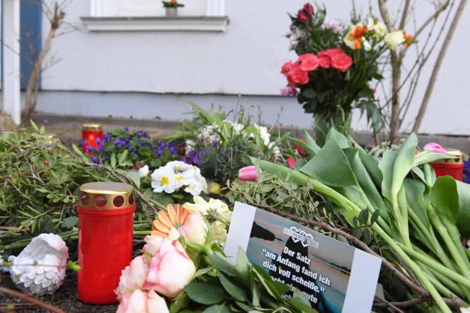Kerzen und Blumen stehen vor dem Eingang des Hauses, in dem am 19.03.2019 eine 18-jährige Frau tot aufgefunden wurde.