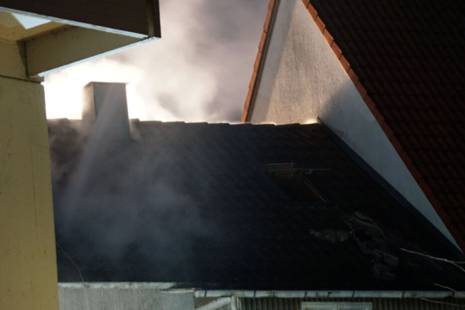 Qualm dringt aus dem Dach des Hauses.